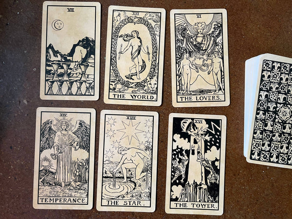 Cards from Tea Stained Tarot on a table along with the rest of the deck