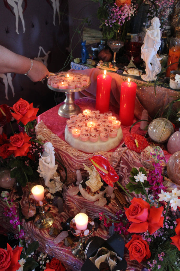 A hand reaching into an opulent altar space to light a candle