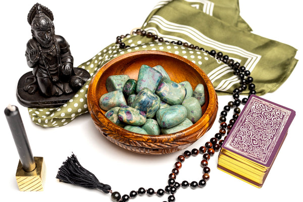 A wooden bowl filled with tumbled Ruby Fuschite