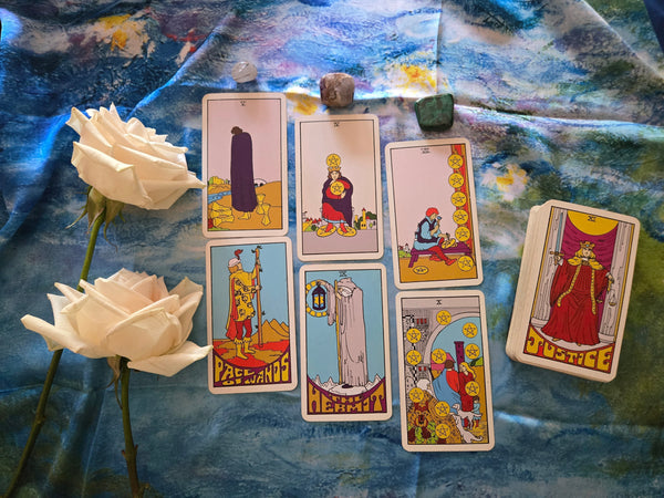 Tarot cards laid out on a silk cloth with white roses