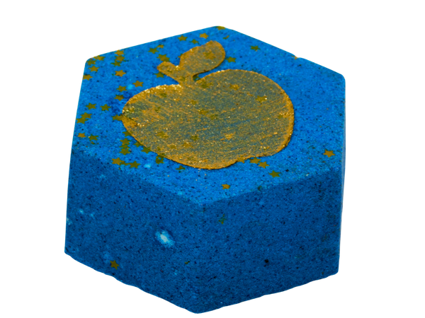 Side angle of Opal Apple Bath Fizz showing the depth of the blue hexagon shape with gold apple detail and star glitter on top