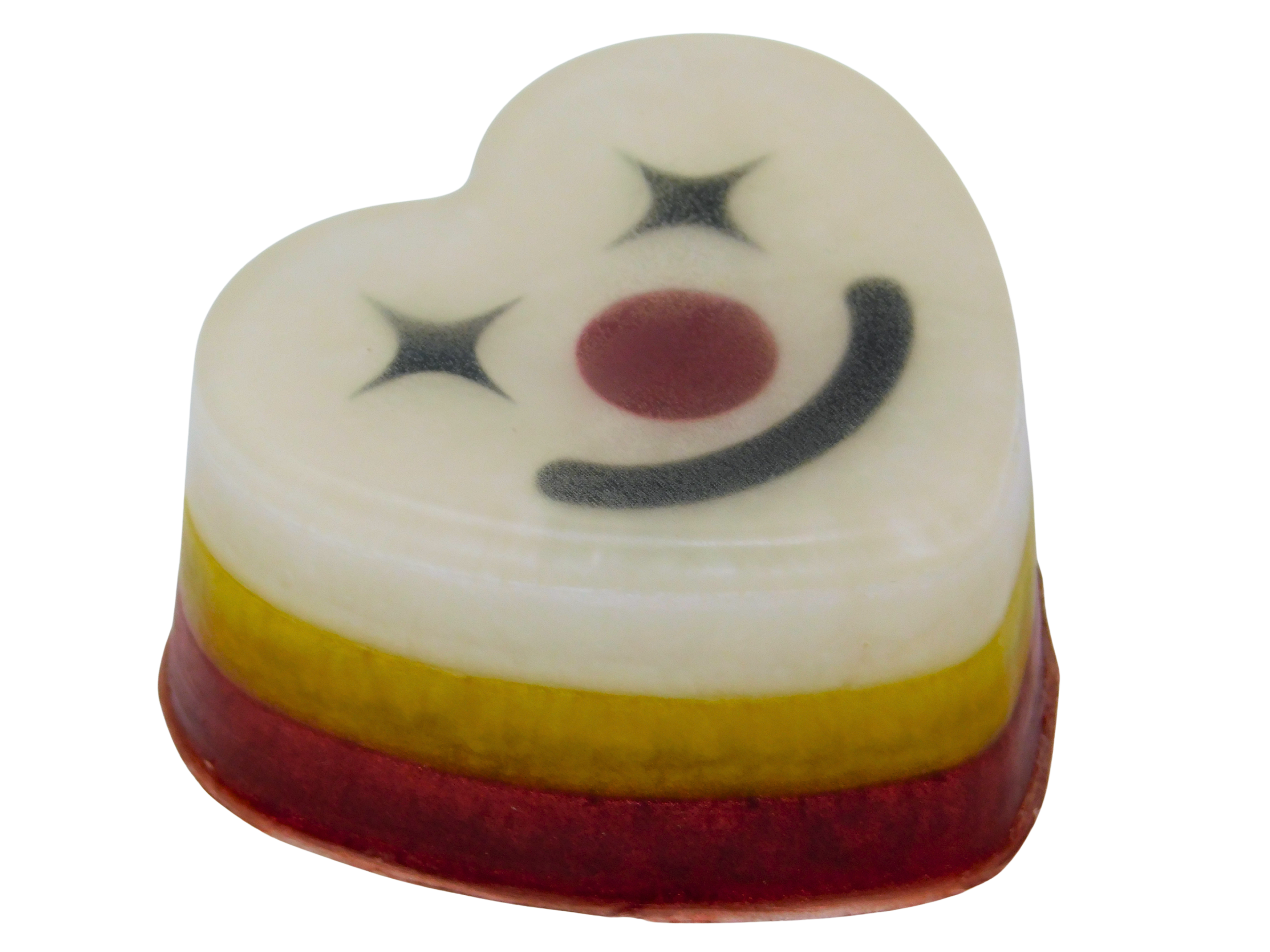 Funhouse Soap angled view showing layered red, yellow, and white heart-shaped bar with clown face on top featuring star eyes, dark red nose, and black smile