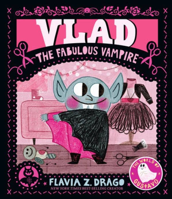 Front cover of Vlad, The Fabulous Vampire - a wide-eyed vampire with rosy cheeks sewing a pink and black cape in a costume workshop, illustrated in bold pink and black folk art style