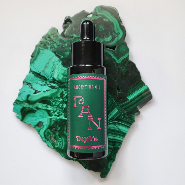 Anointing oil bottle with green label on a green stone background