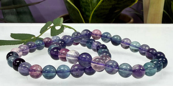 Multicolored beaded bracelets on a white surface with a blurred background