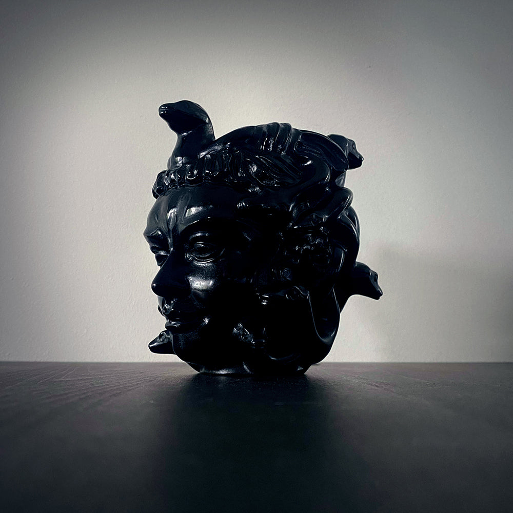 Shadowy image of a black obsidian medusa head