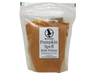 Pumpkin Spell Bath Potion in a clear biodegradable standup bag with Witch Baby label showing Pumpkin Spice and Oud scent, filled with warm orange pumpkin and clay powder, 7 oz