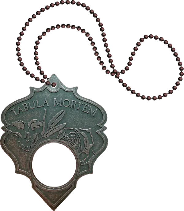 Decorative pendant with 'Tabula Mortem' text and beaded chain on a white background
