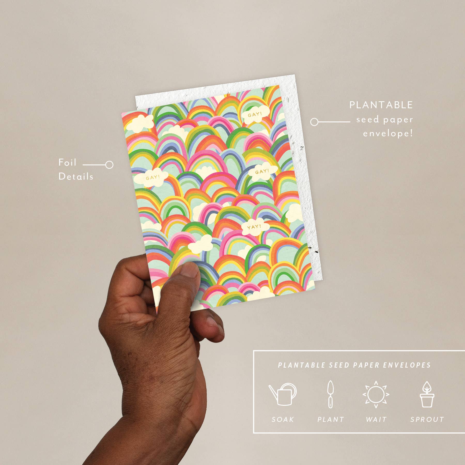 Hand holding a plantable seed paper envelope with rainbow pattern on a beige background