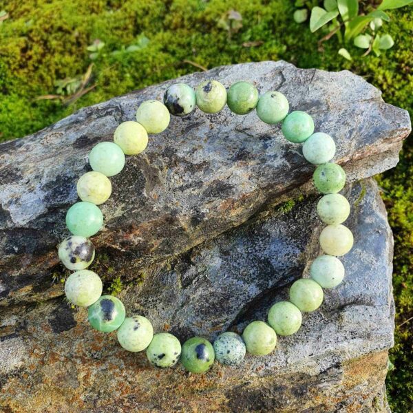 Chrysoprase is pale green with dark and light spots, these beads are strung on a stretch bracelet