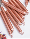 Soft rose-gold chime candles in a pile