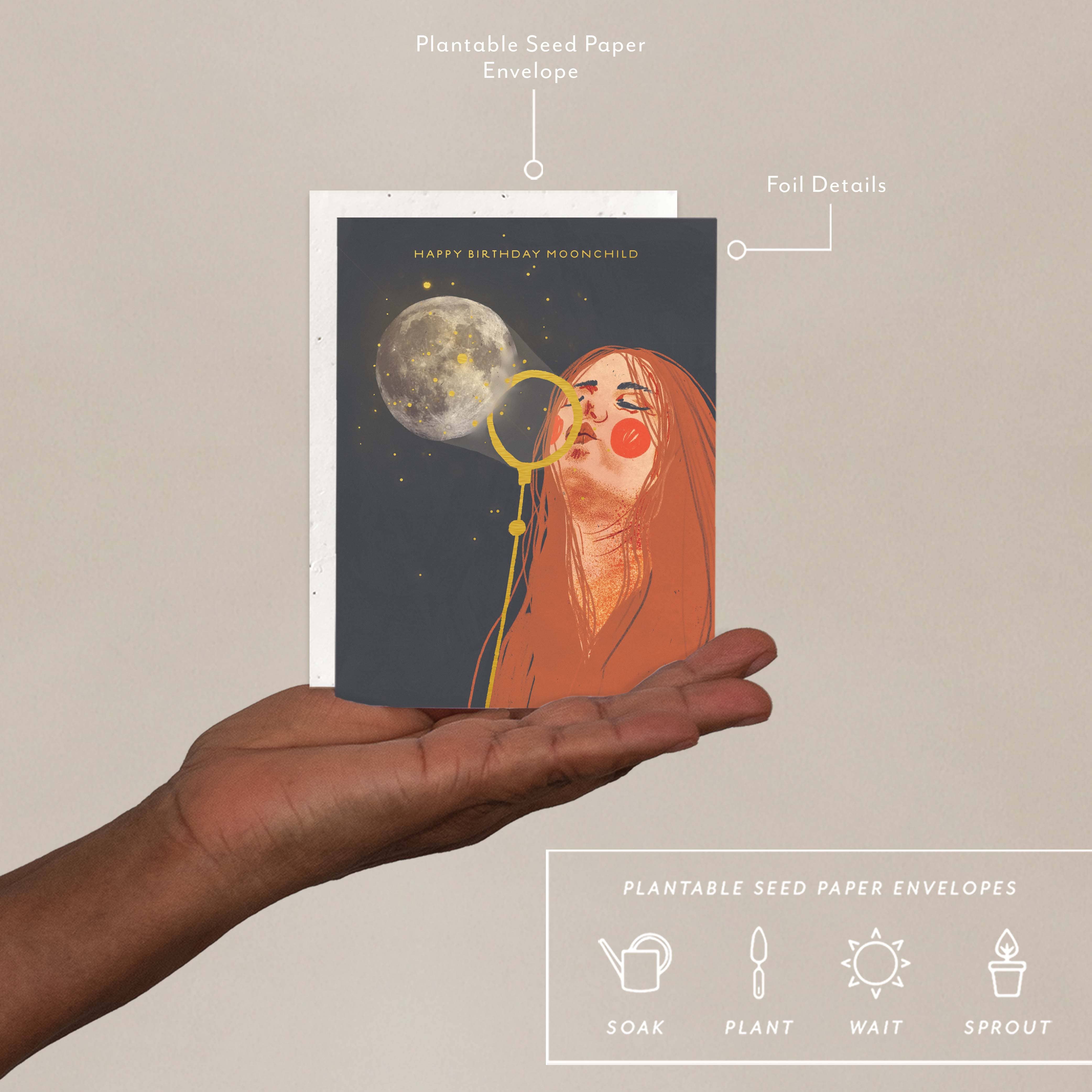 Hand holding a card with a design of a woman and moon, labeled 'Plantable Seed Paper Envelopes'.