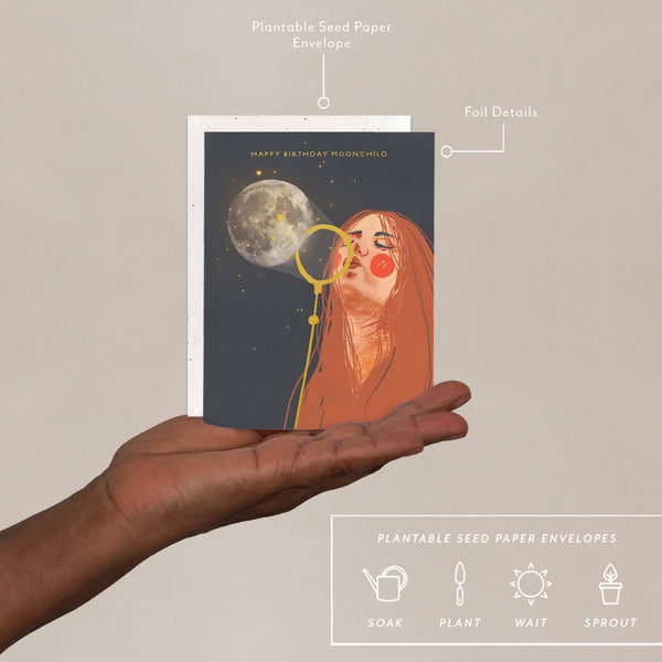 Hand holding a card with a design of a woman and moon, labeled 'Plantable Seed Paper Envelopes'.
