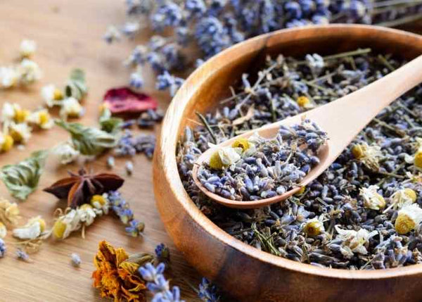 Herbs in a bowl with a wooden spoon